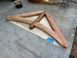 A piece of wood is sitting on top of a piece of plywood on the ground.