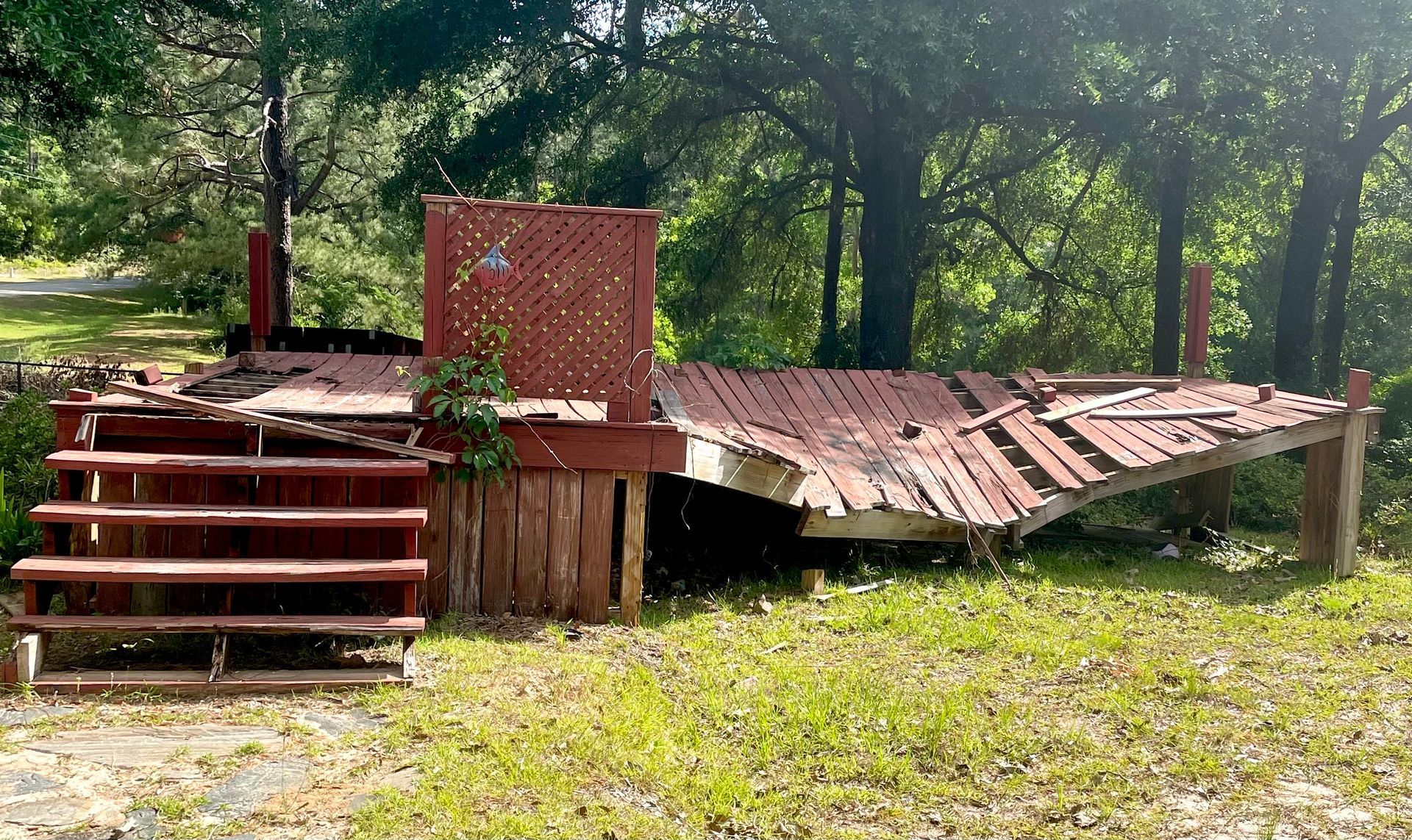 Rusty abandoned shed with collapsed roof in a grassy wooded area