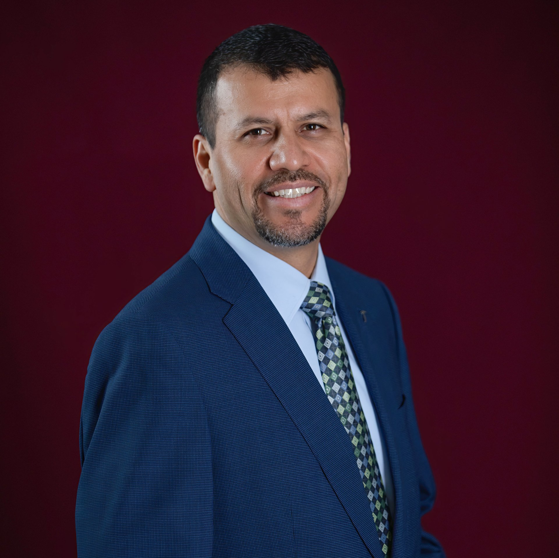 A man in a suit and tie is smiling for the camera.
