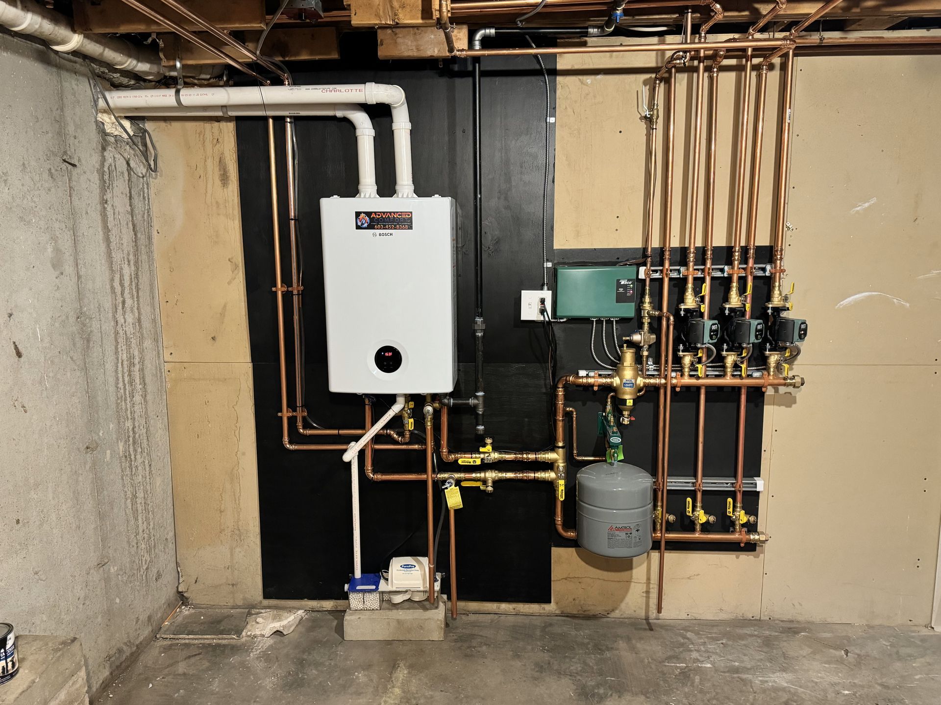 A white water heater is mounted to a wall in a basement