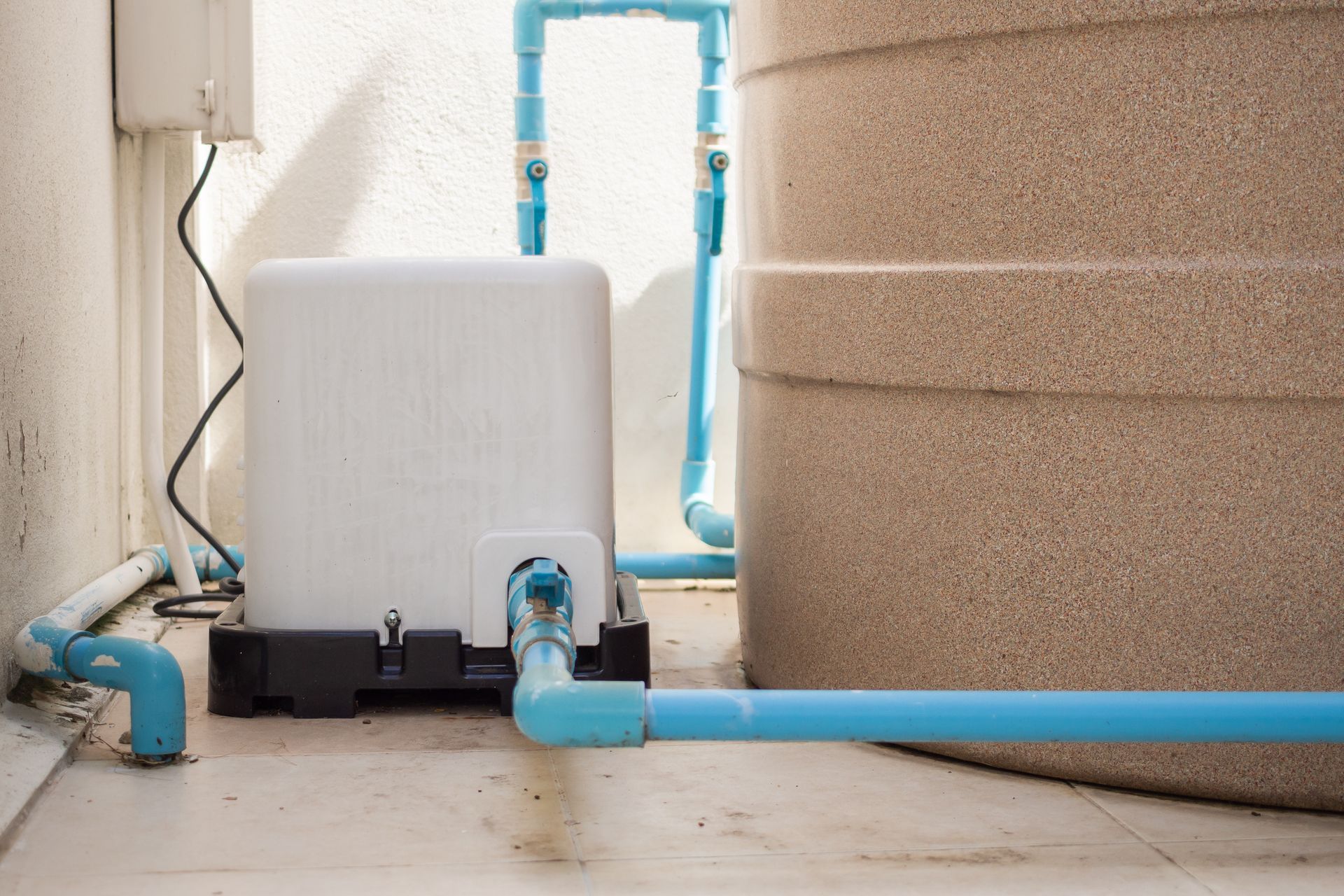 A water pump is sitting next to a water tank.
