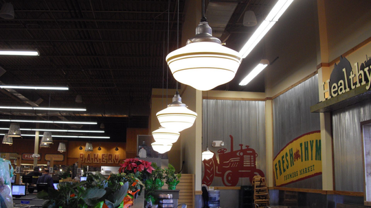 Interior of a grocery store with hanging lights, flowers, and a 