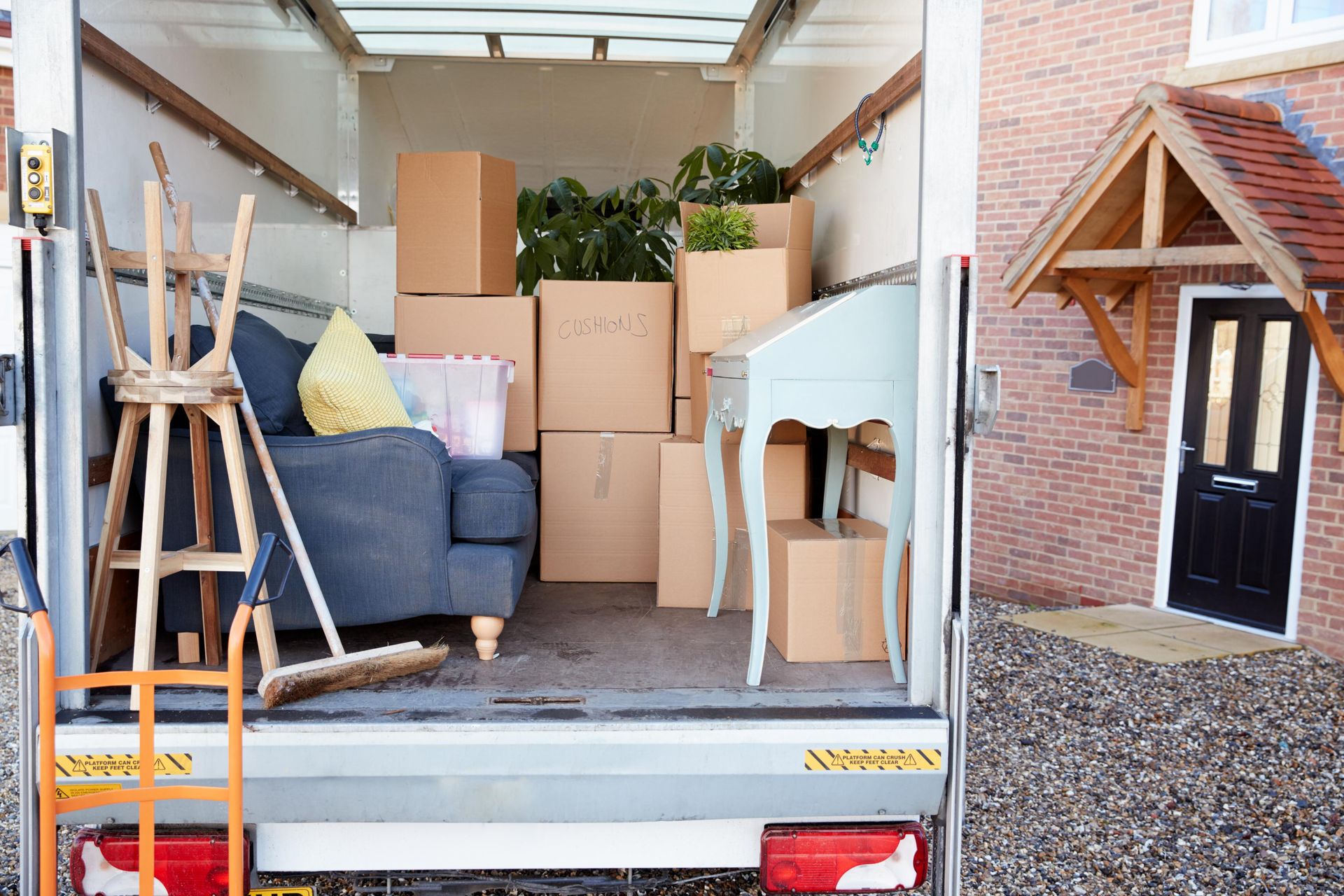A Moving Truck Filled with Furniture and Boxes Is Parked in Front of A House — Dunford Removals in Childers, QLD