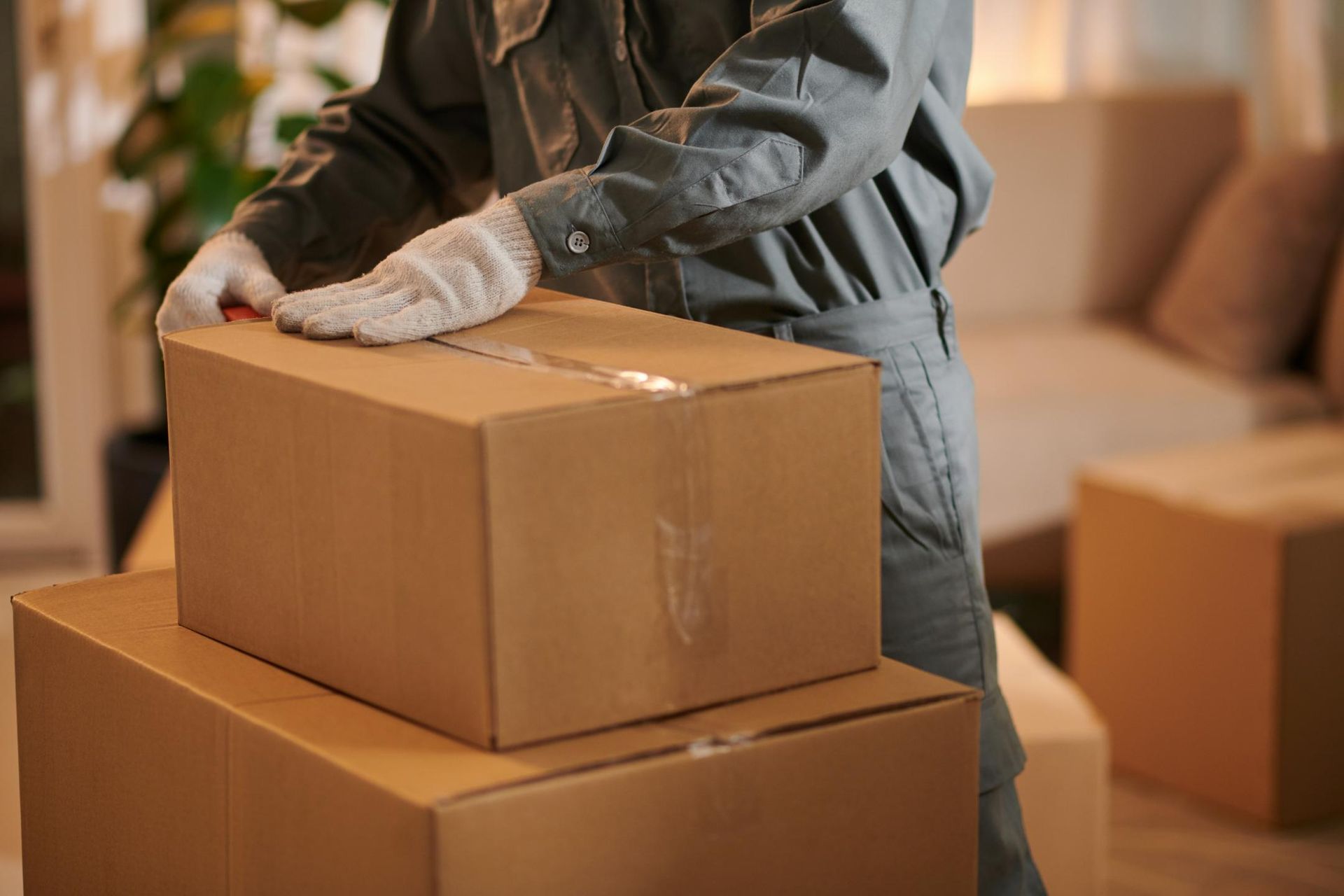 A Man Is Stacking Boxes on Top of Each Other in A Living Room — Dunford Removals in Qunaba, QLD