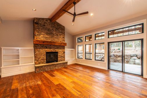 An empty living room with hardwood floors and a fireplace