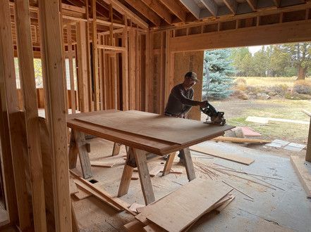 A man is using a circular saw to cut a piece of wood