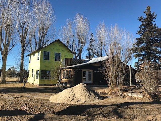 A house under construction with a pile of dirt in front of it.