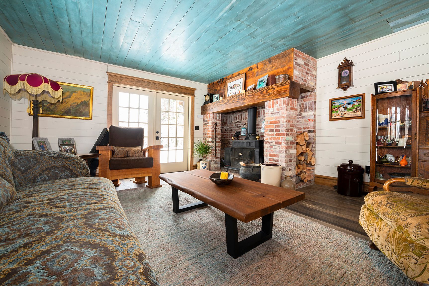 A living room with a couch , chair , coffee table and fireplace.