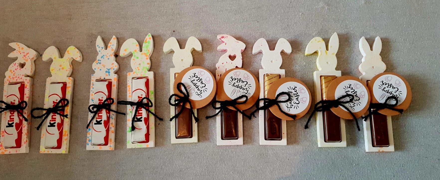 Assortiment de décorations de lapins faites à la main, avec des détails rouges et noirs, disposées en rangée.