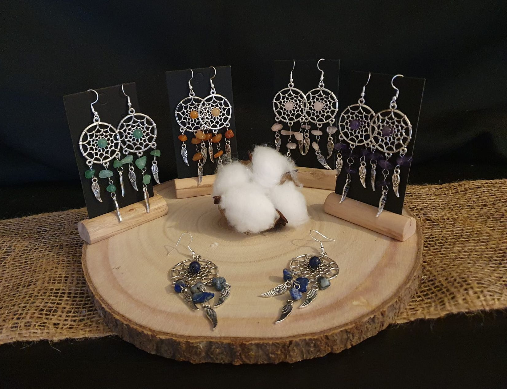 Présentoir à bijoux sur une tranche de bois avec boucles d'oreilles en fil de fer, centre de table en coton.