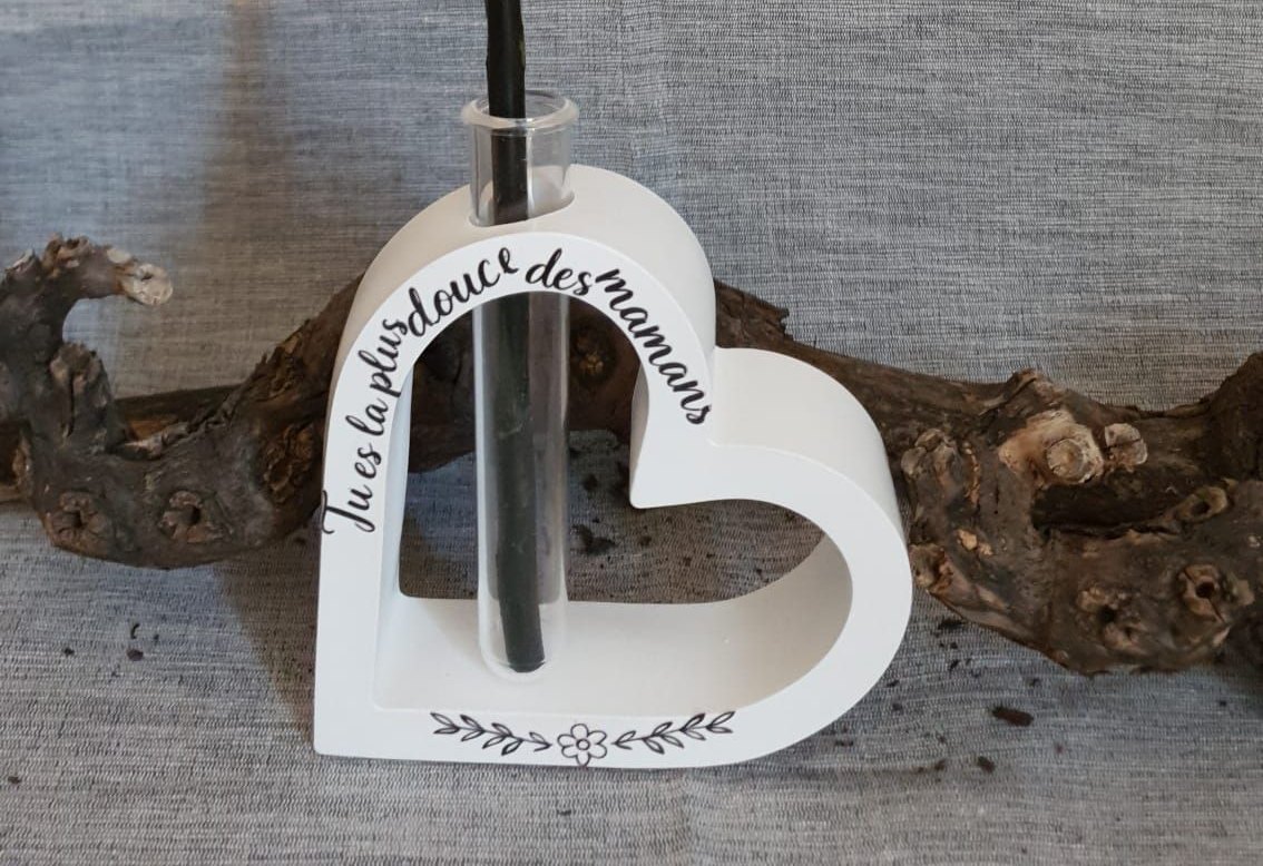 Horloge blanche en forme de cœur avec inscription française sur fond de bois flotté, sur fond de tissu gris