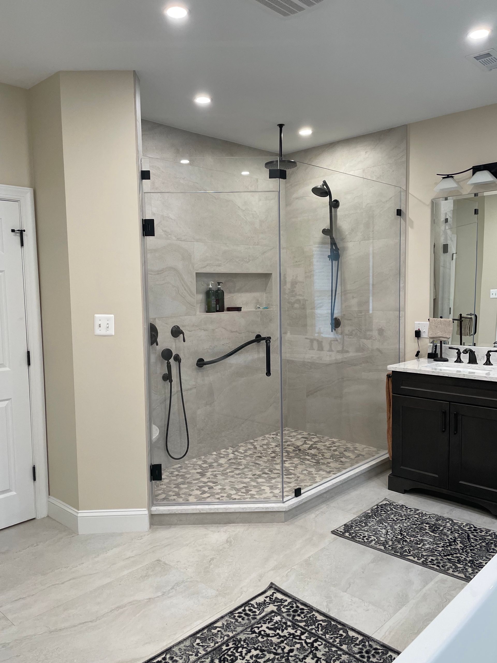 Modern bathroom with glass walk-in shower, tiled walls, and vanity sink
