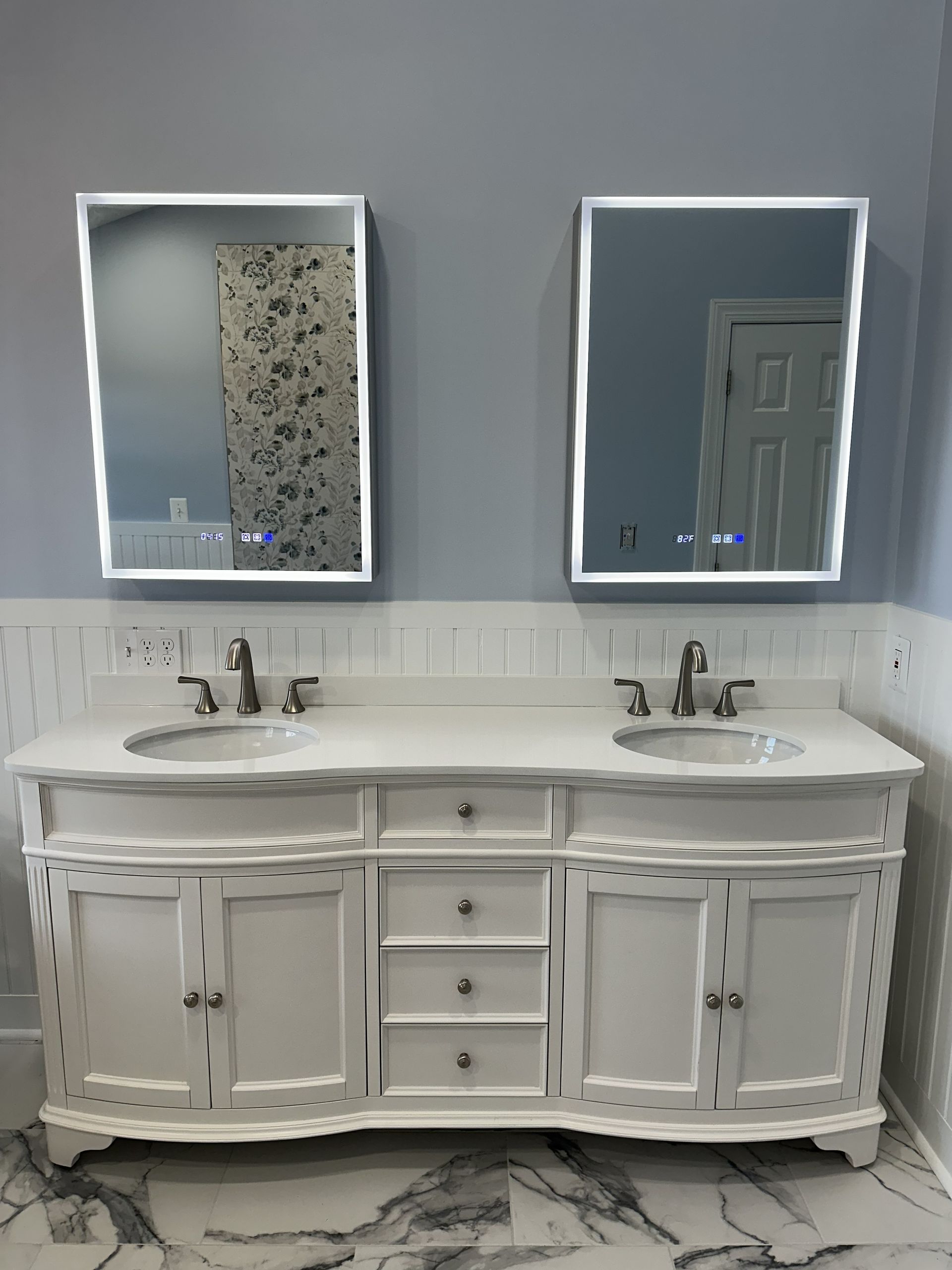 White double vanity with two mirrors and sinks in a bathroom.