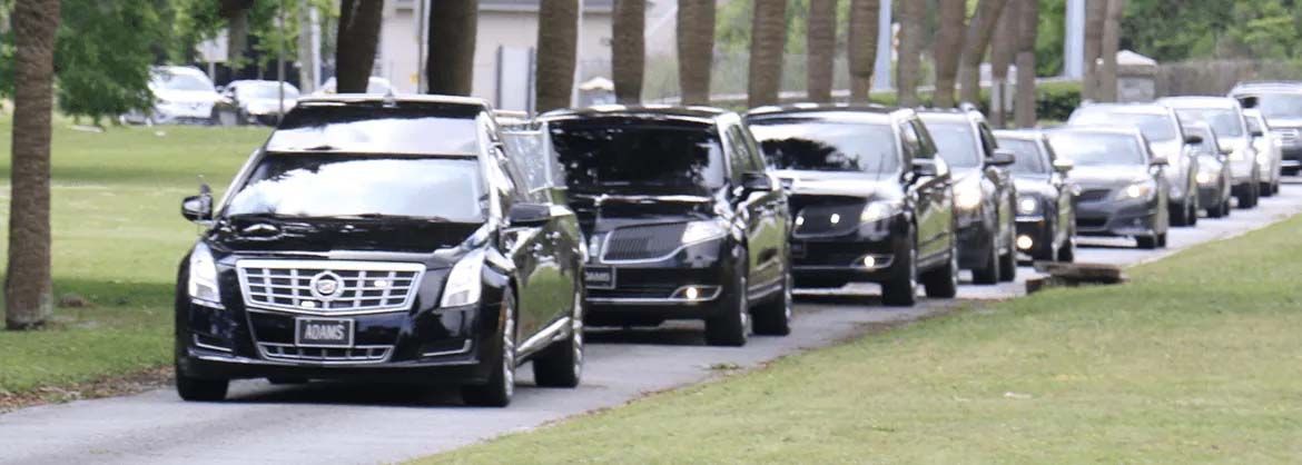 A row of cars are parked on the side of a road.