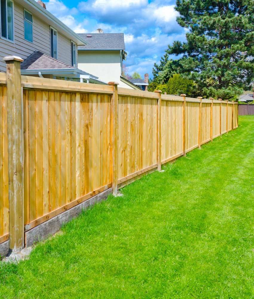 A Wooden Fence Surrounds a Lush Green Lawn in a Backyard — Slim Fox Home Improvements in Mooroobool, QLD