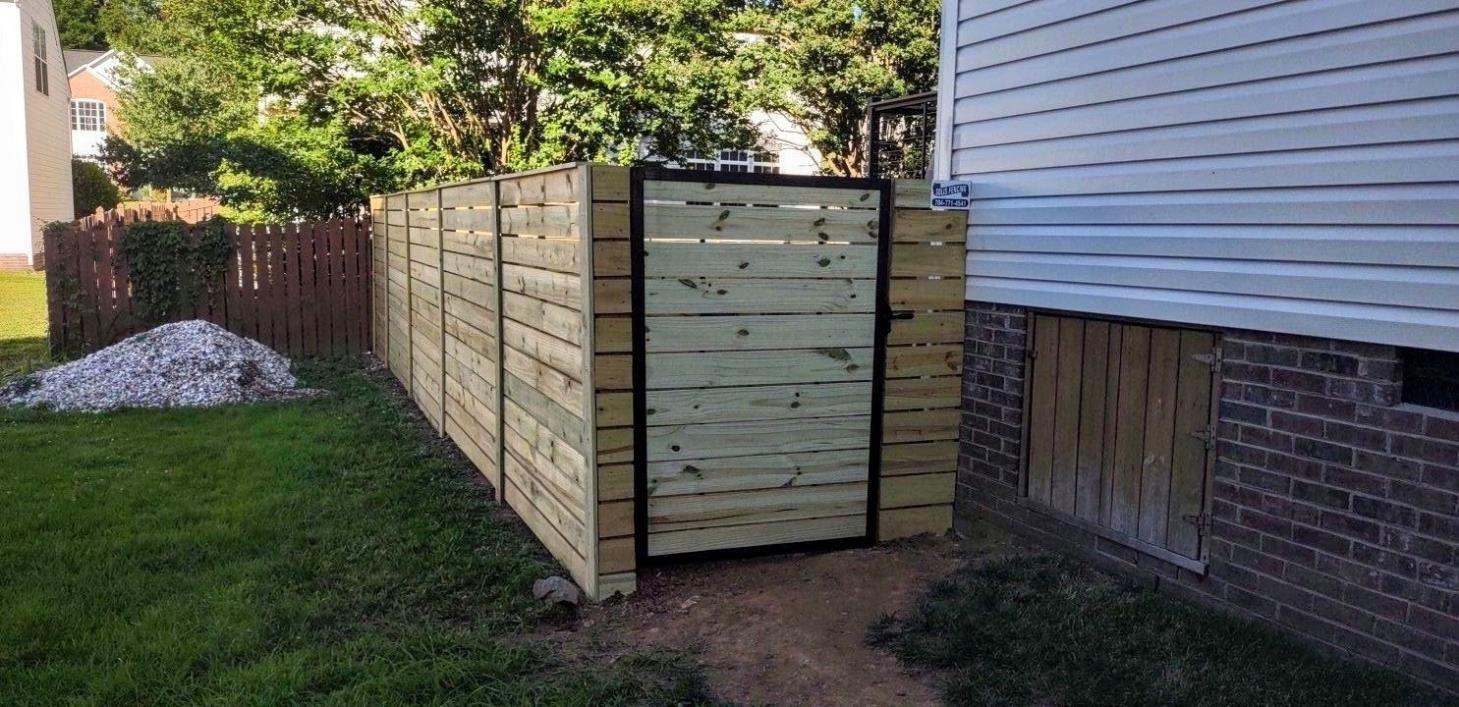 A wooden fence with a gate in the backyard of a house.