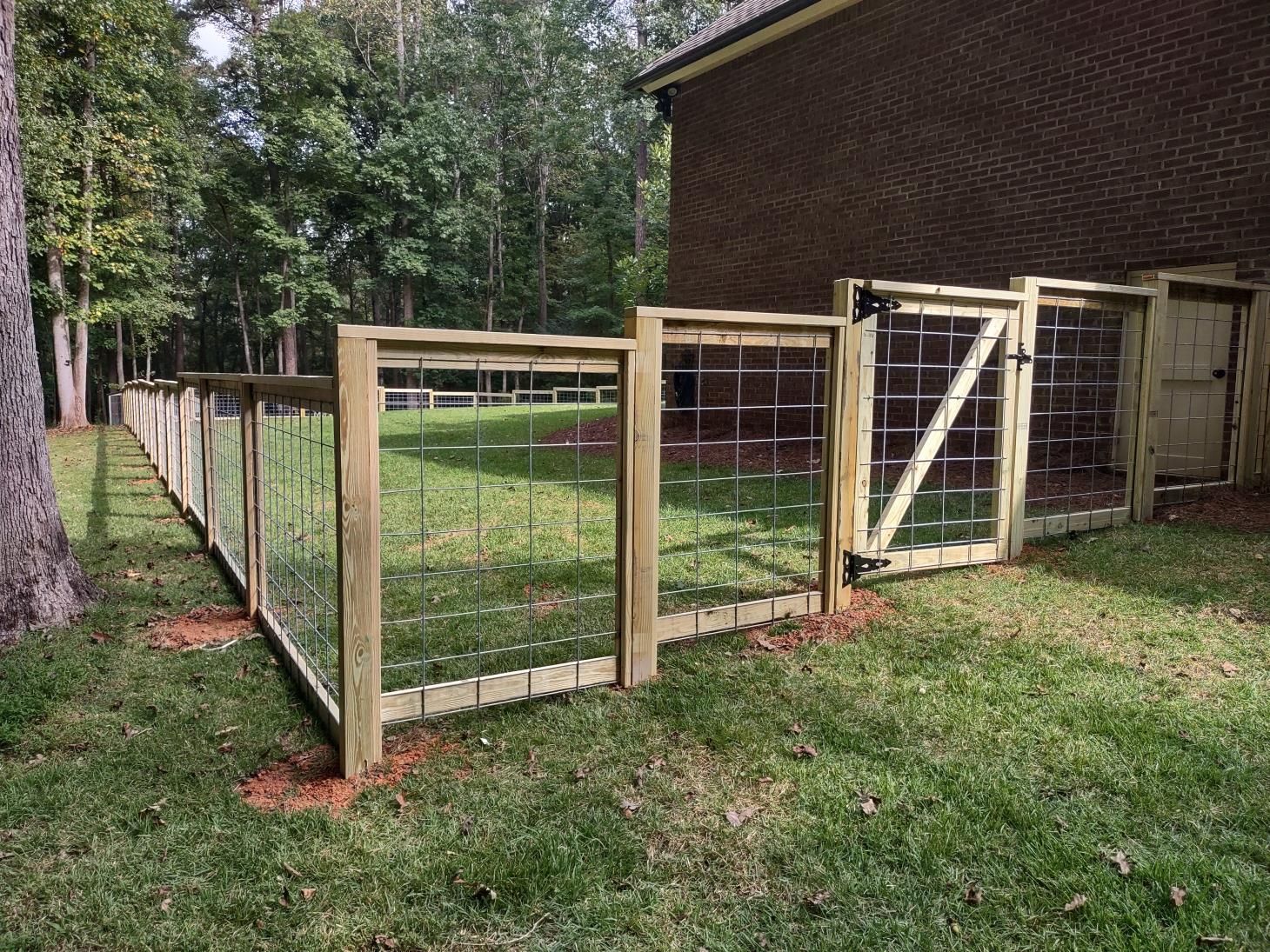 A chain link fence surrounds a yard with a playground in the background.