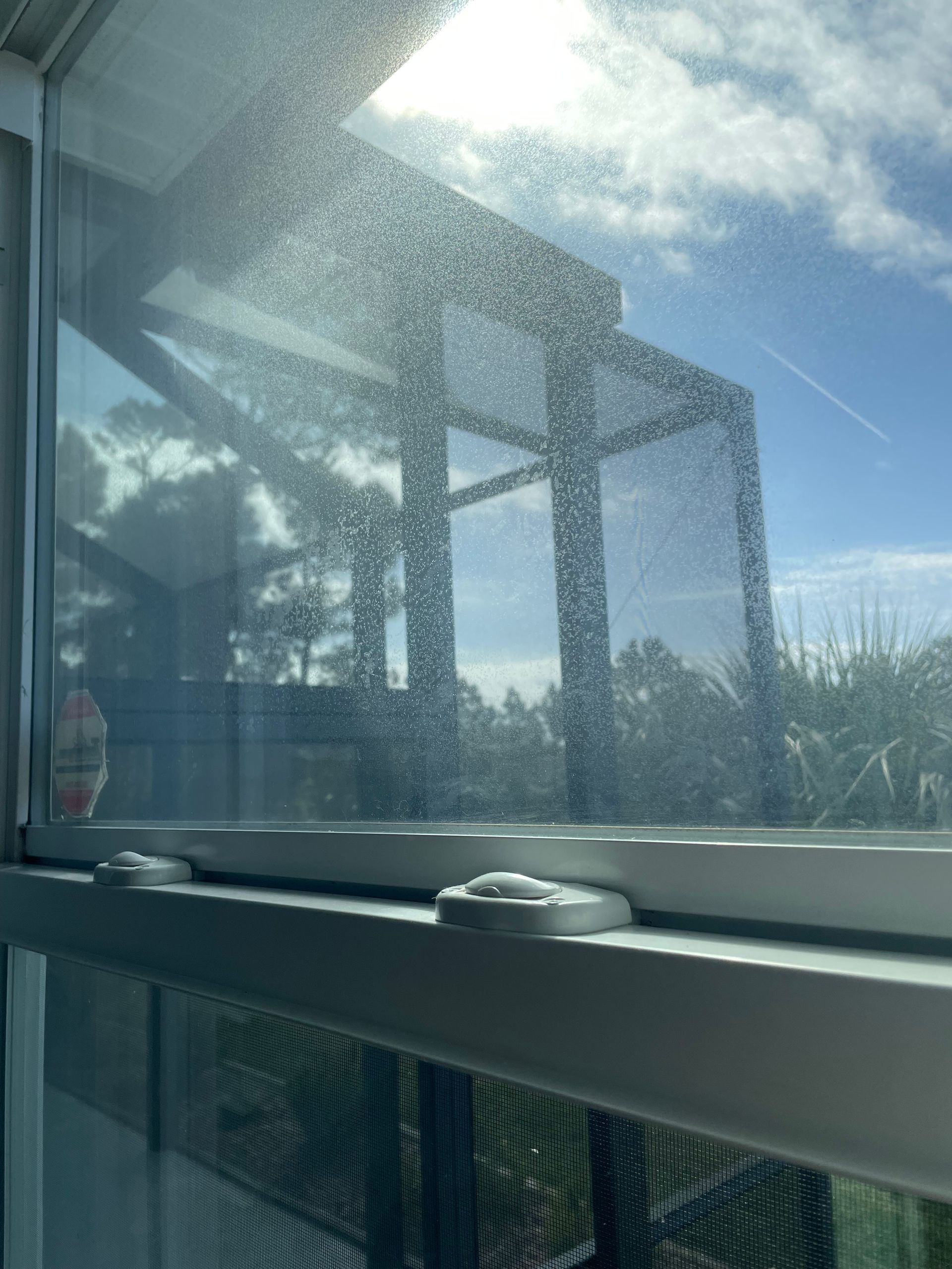 A close up of a window with the sun shining through it.