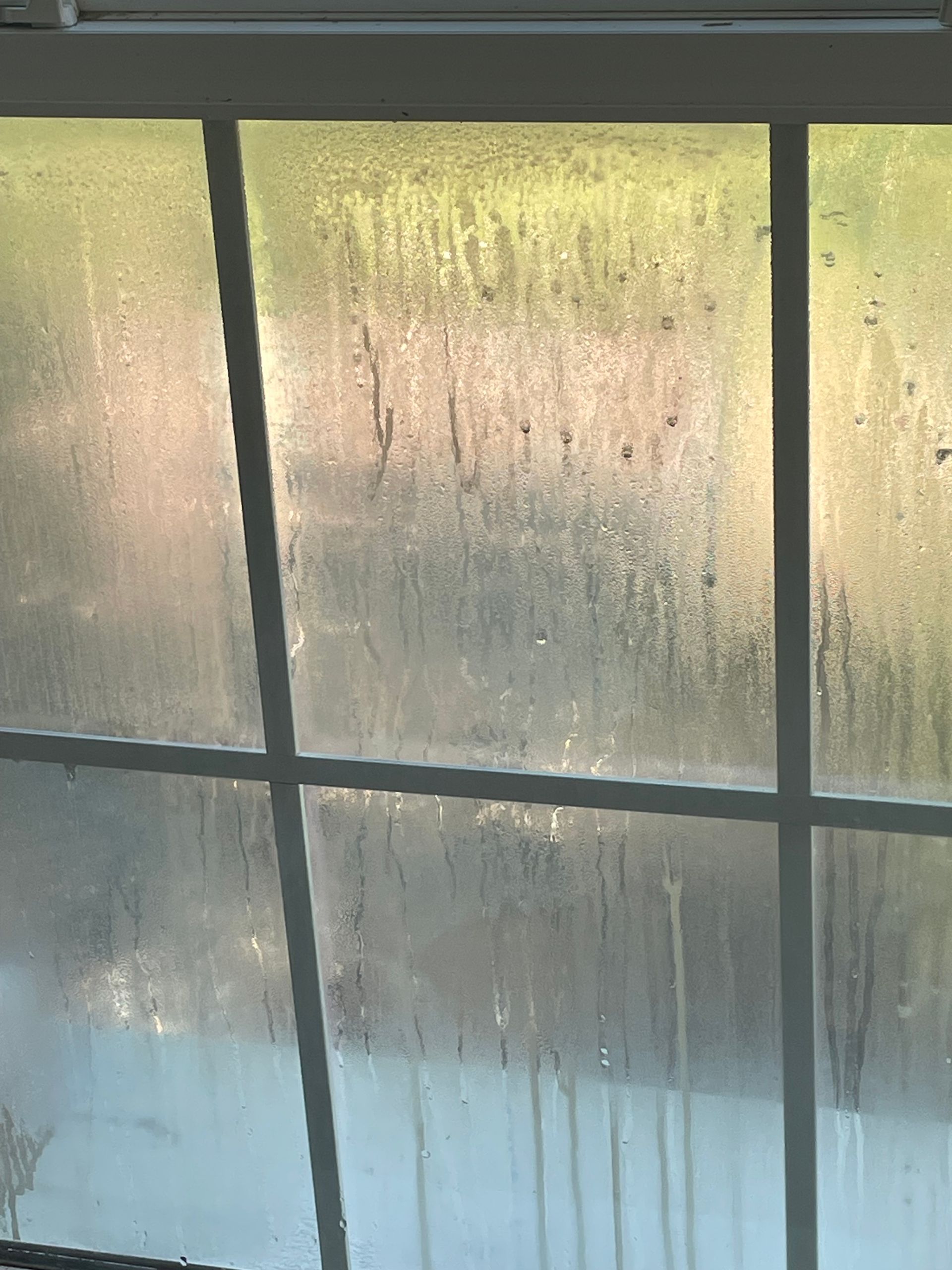 A close up of a window with condensation on it.