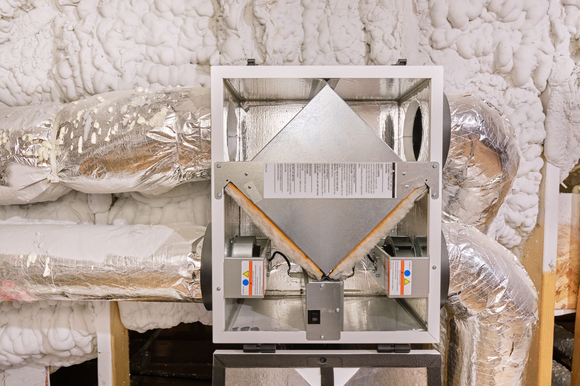 Unité de climatisation avec conduits dans une pièce isolée.