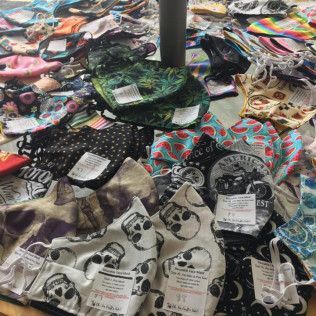 Pile of various patterned face masks for sale, indoors.
