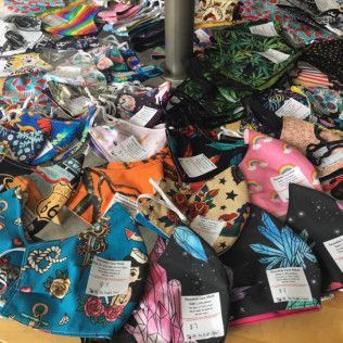 Pile of assorted fabric face masks in various patterns and colors.