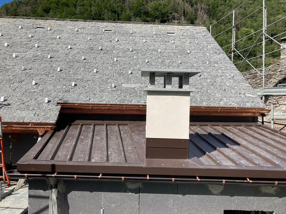 Tecnico installa scossaline e pluviali su una copertura