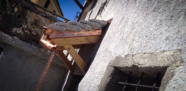 Dettaglio di grondaia e scossalina metallica su una copertura