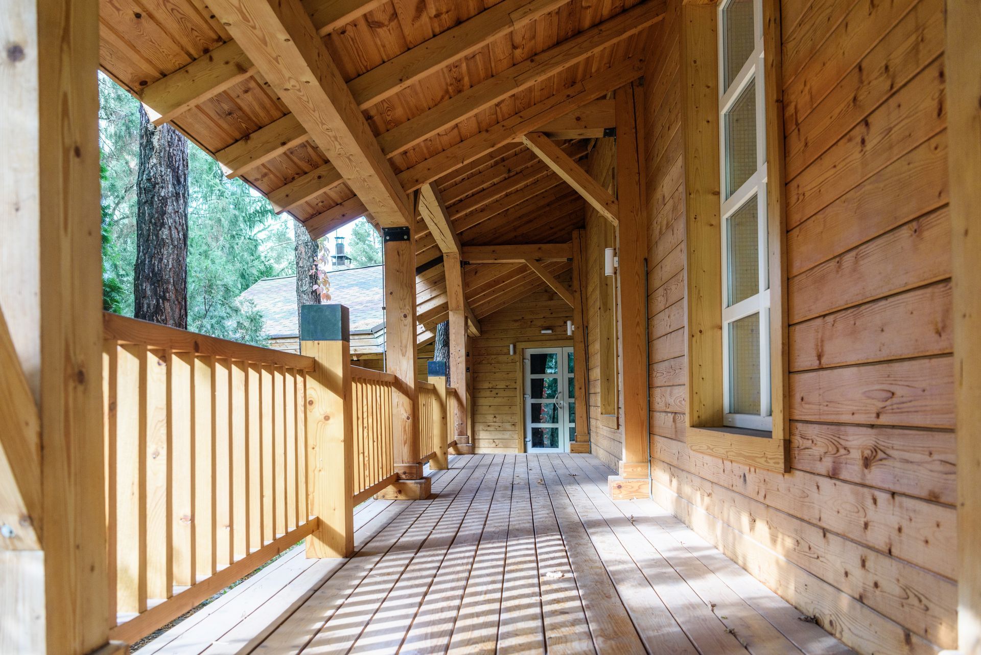 A wooden house with a covered porch and a wooden railing.