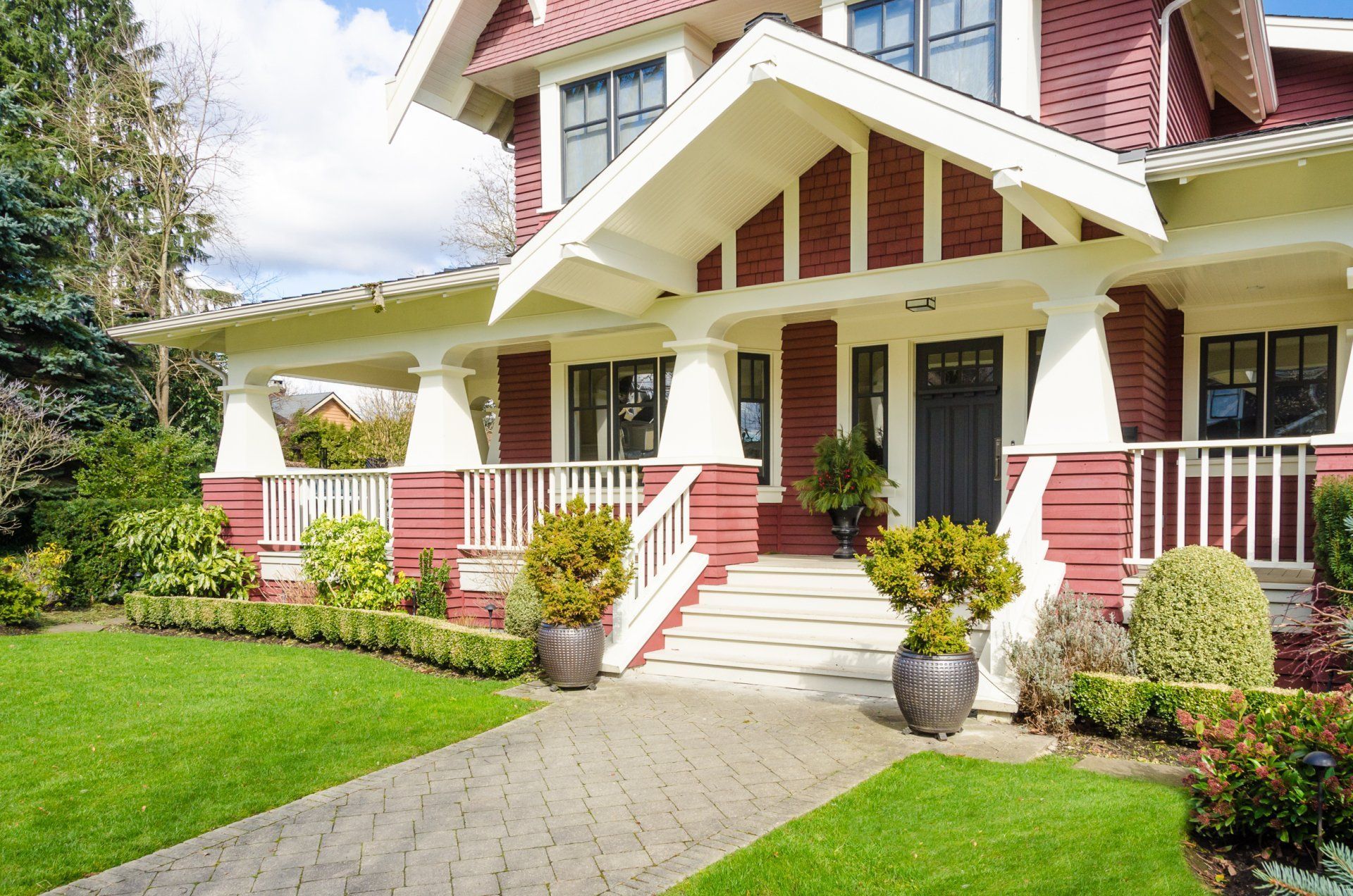 A large red and white house with a brick walkway leading to the front door.