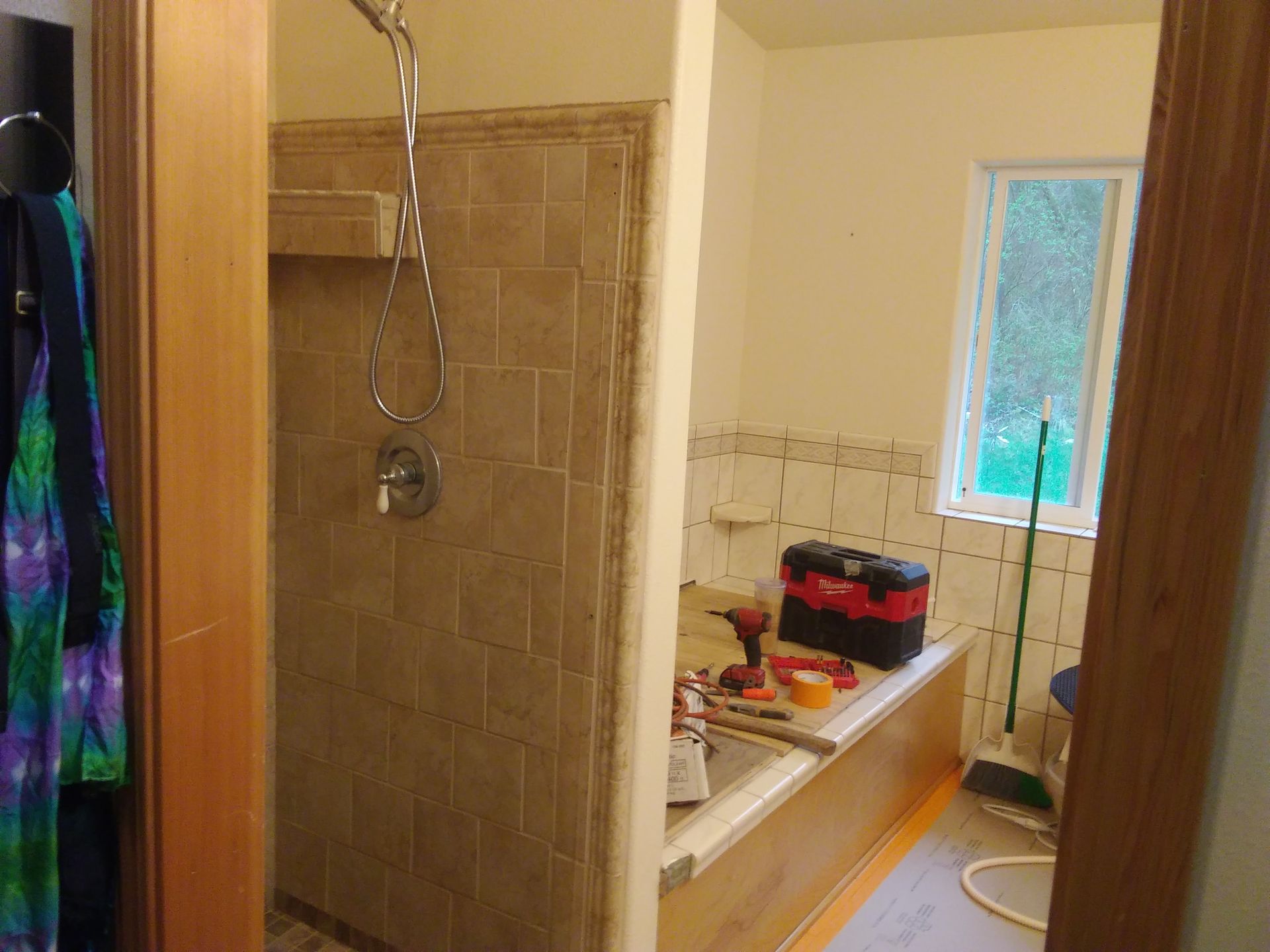 A bathroom under construction with buckets of paint and a ladder.