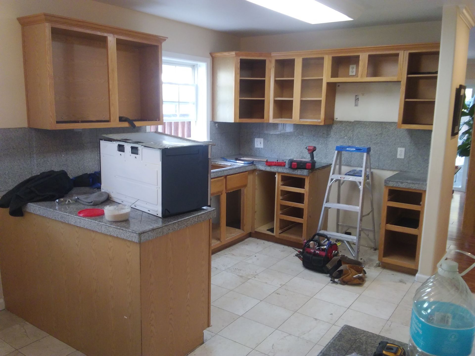 A kitchen under construction with white cabinets and a sink.