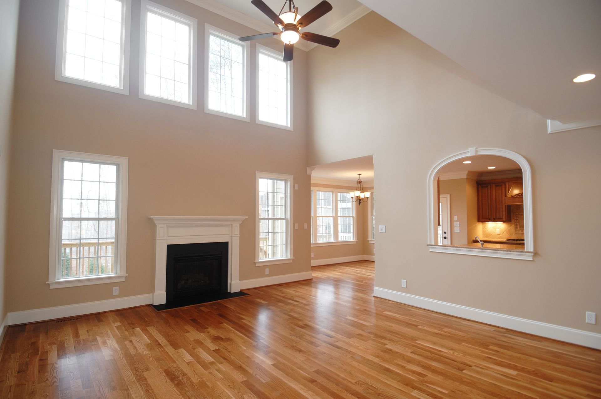 An empty living room with hardwood floors and a fireplace.