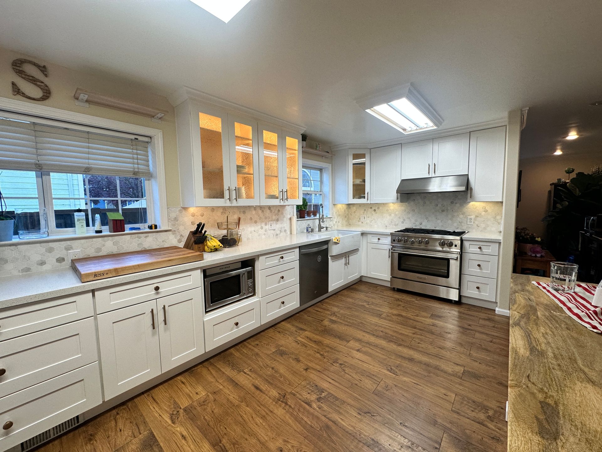 A kitchen with white cabinets and hardwood floors