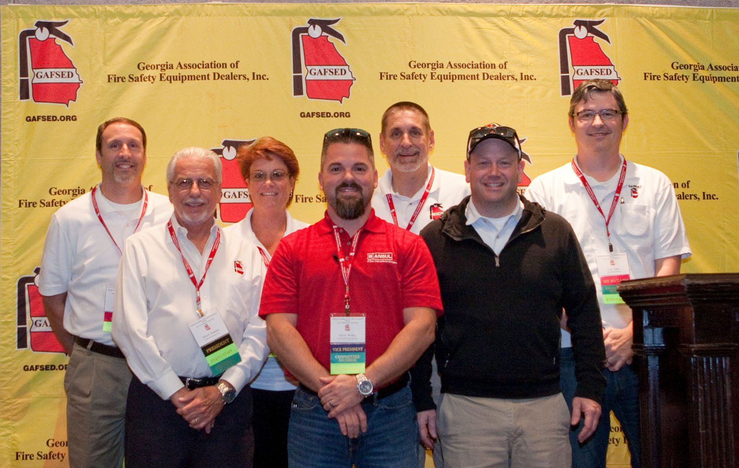 A group of people standing in front of a fire extinguisher sign