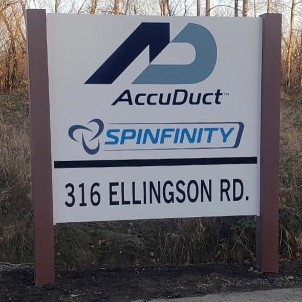 A sign at 316 Ellingson Rd. displays the company logos for AccuDuct and Spinfinity against a natural, outdoor background.