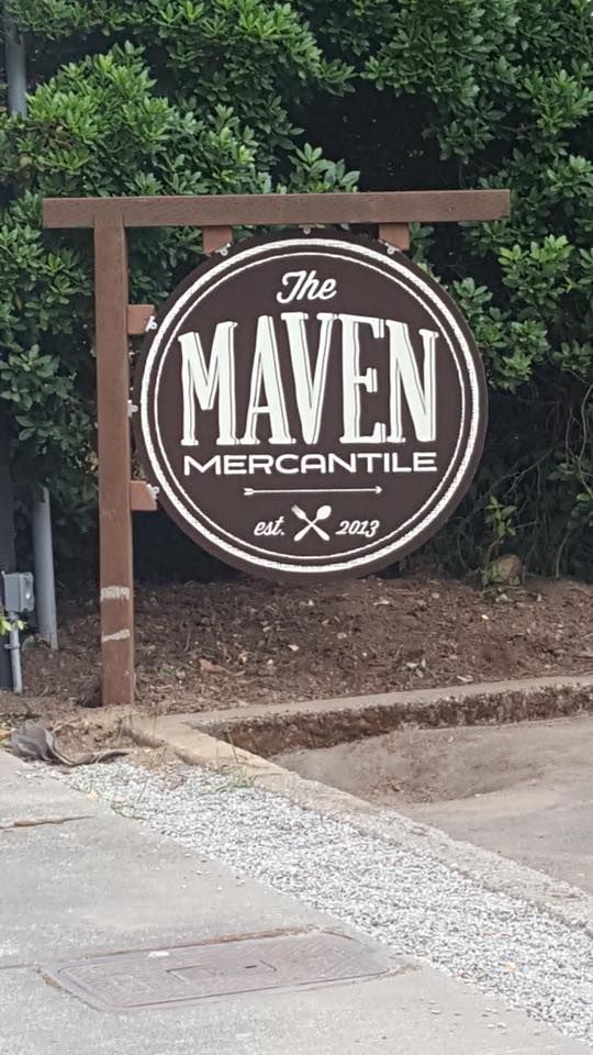 A brown circular hanging sign that reads