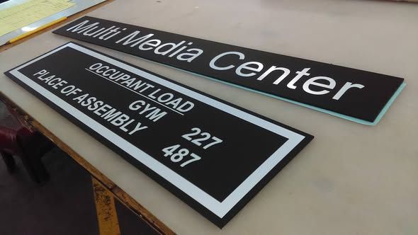 Two rectangular black signs with white lettering reading