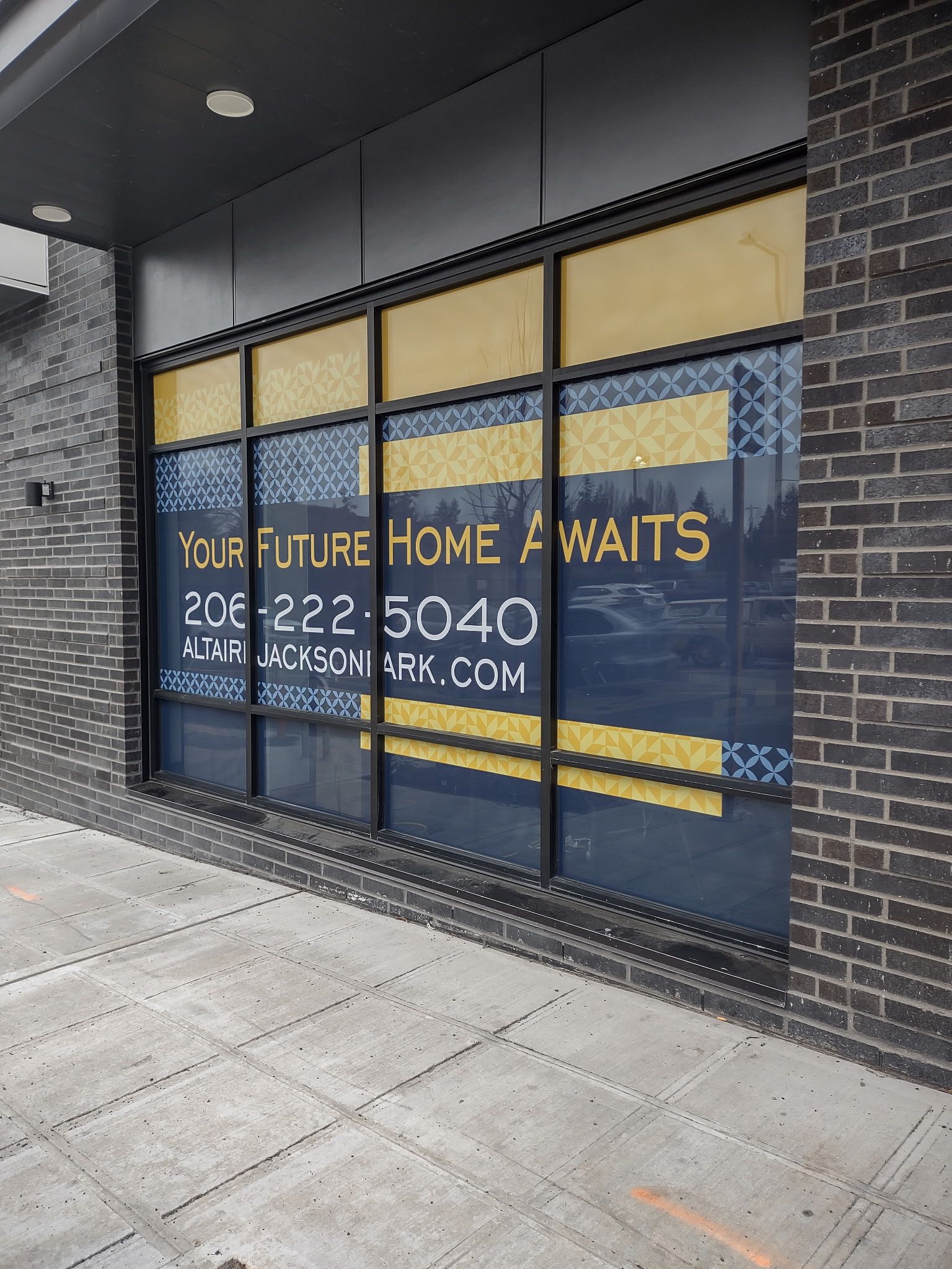Storefront with large window decals reading “Your future home awaits” in a modern building exterior