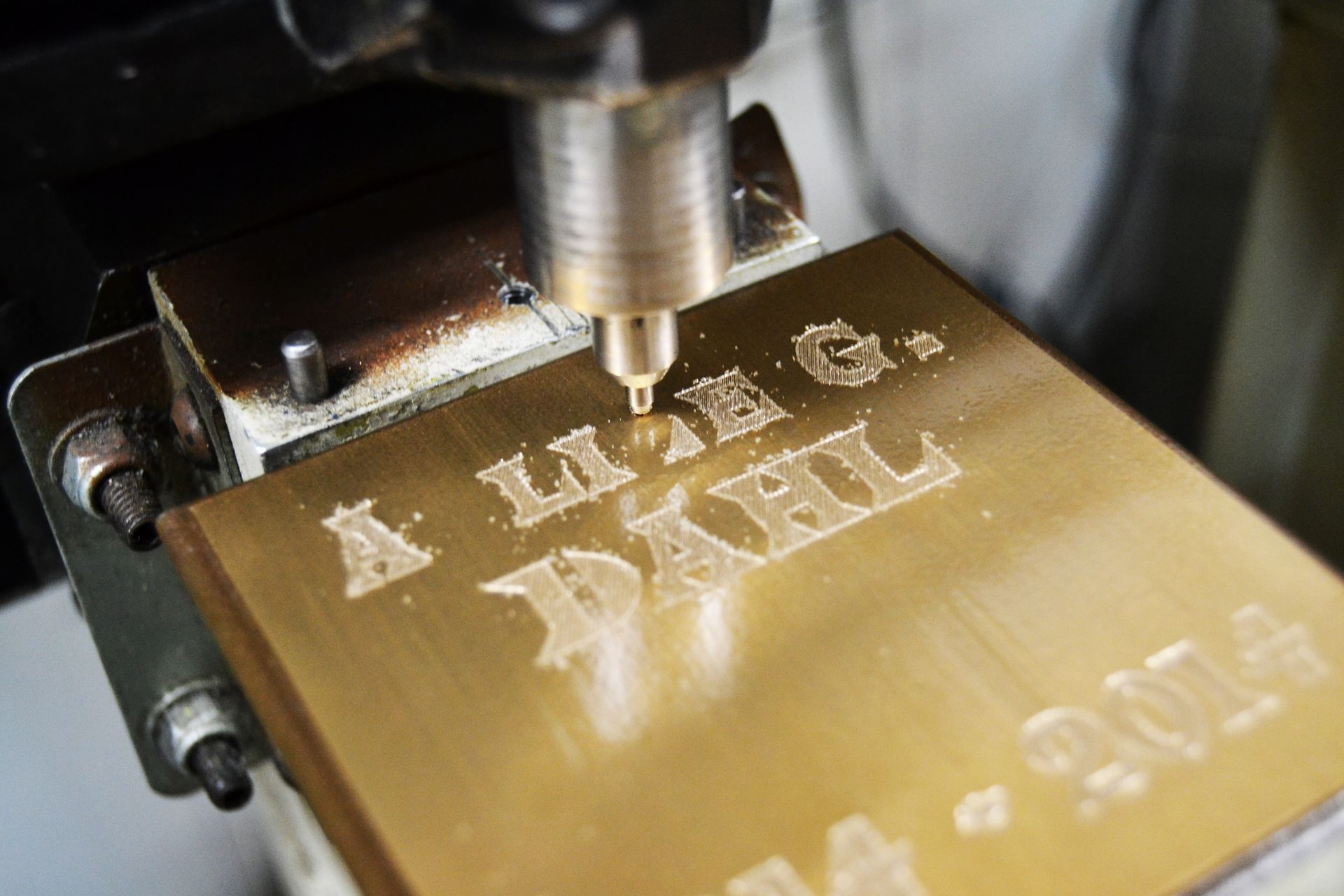 A metal engraving machine carving the name 