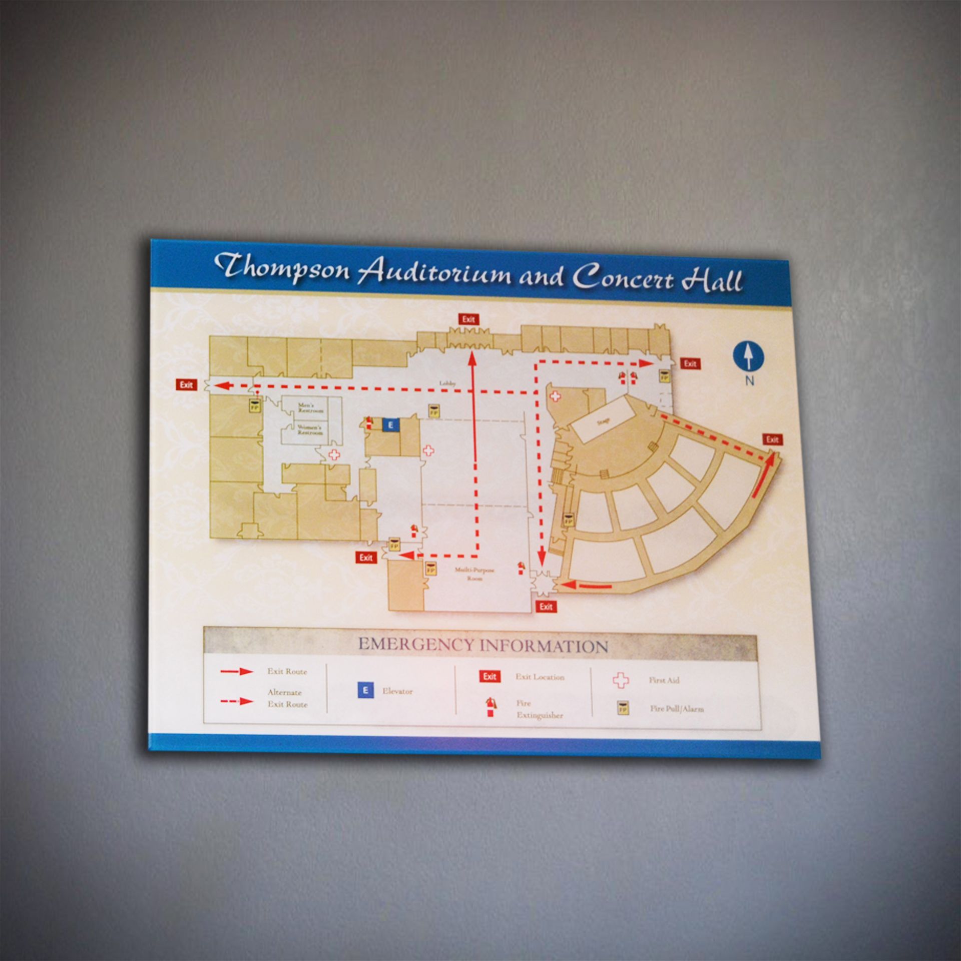 A wall-mounted Thompson Auditorium floor plan sign with emergency exit routes, restrooms, and accessibility information.