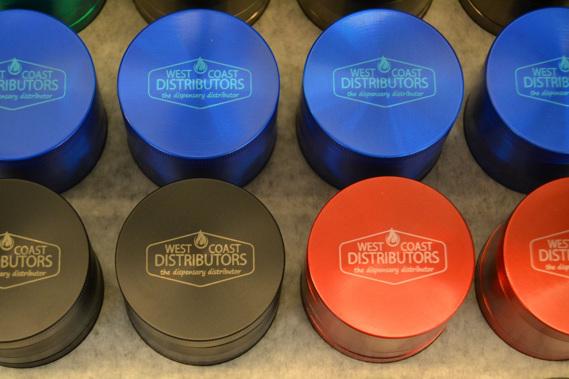 A high-angle shot of several multi-colored circular metal herb grinders with the 