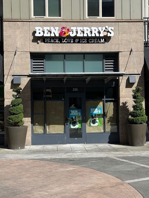 Ben & Jerry’s storefront with glass entrance and potted plants outside