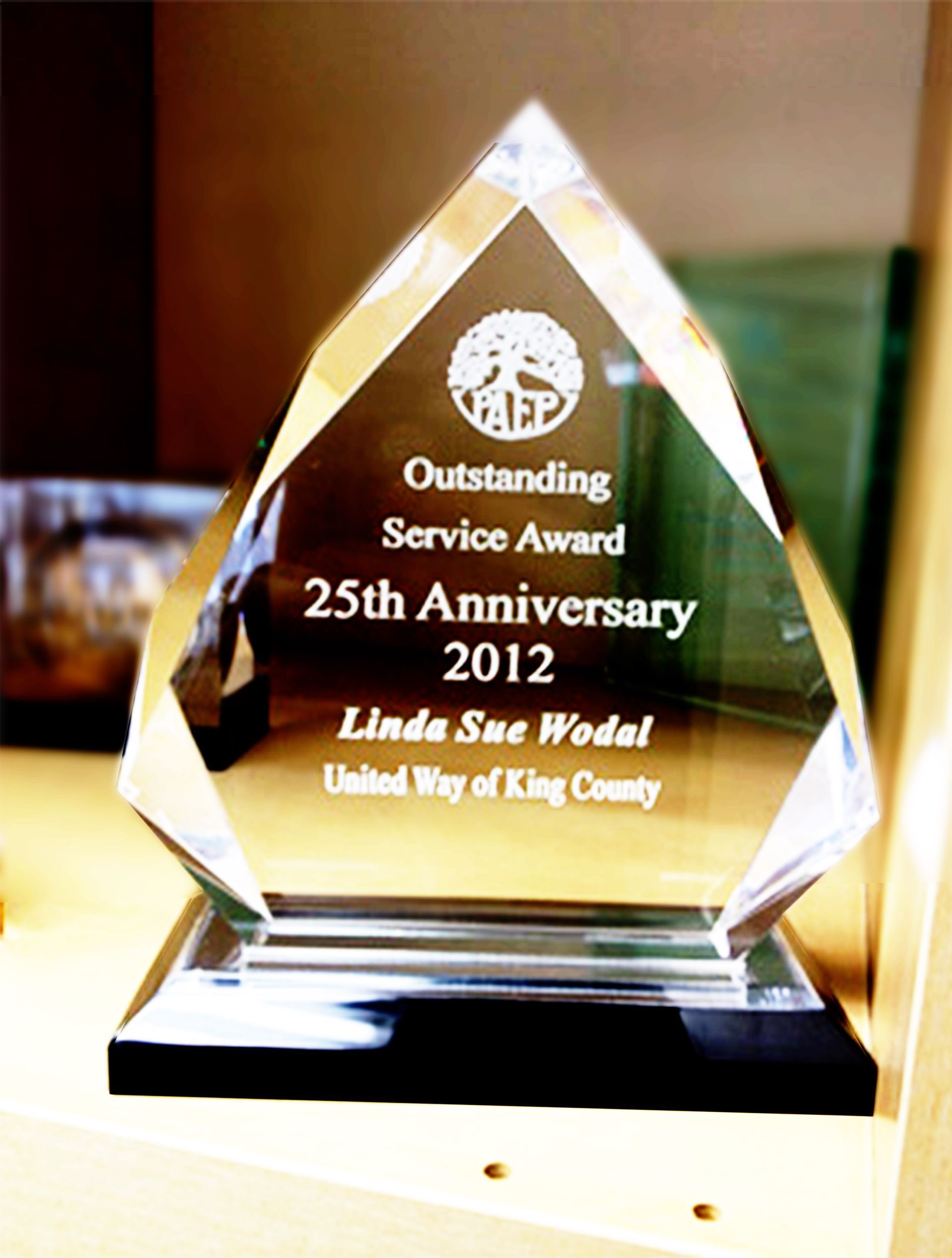 A glass award on a stand, inscribed: 