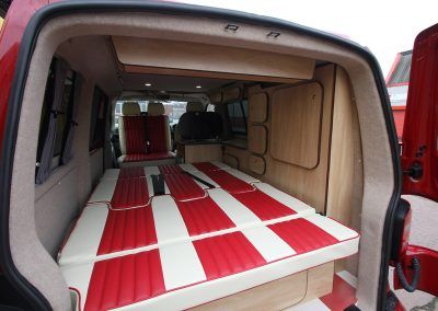 Van with a custom red-and-white striped bed platform in the cargo area