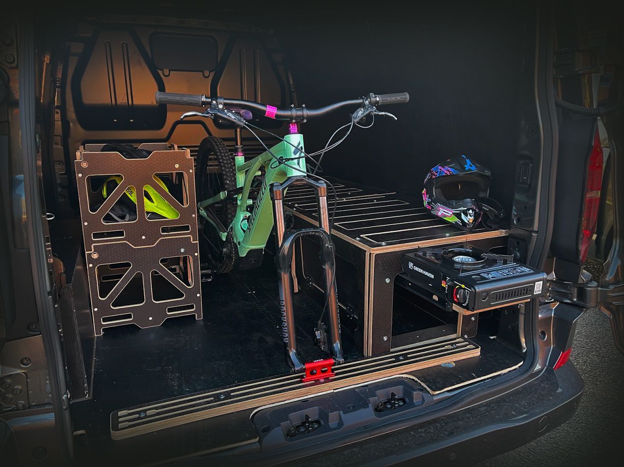3D printer setup with a partly printed object and tools on a workbench in a dark enclosure