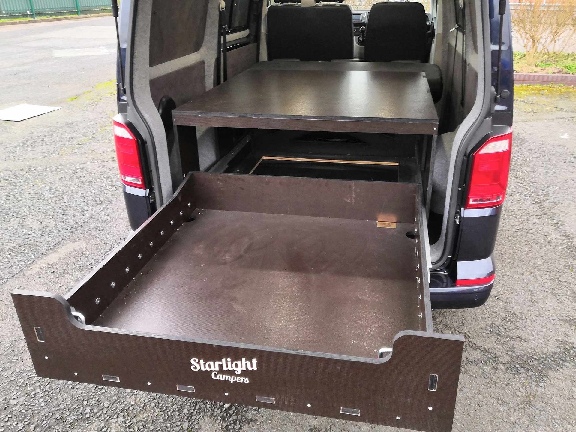 Cargo van with rear drawer slide extended out onto the pavement