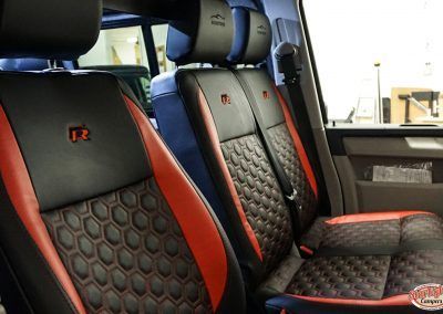 Black and red car seats with hex pattern and R2 logos inside a vehicle interior