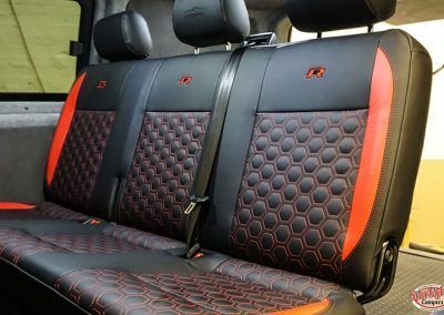 Black and red car seat covers with hex pattern and red trim installed on rear seats