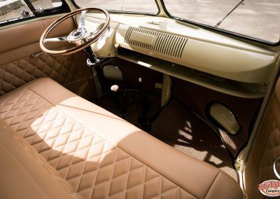 Vintage car interior with tan quilted seats, cream dashboard, and steering wheel